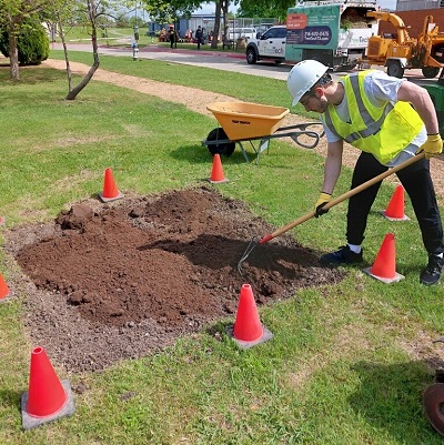 Seff Islam Al-Ghafry loosens dirt for butterfly garden.