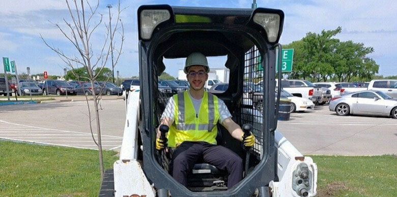 Seff Islam Al-Ghafry poses inside bobcat machine.