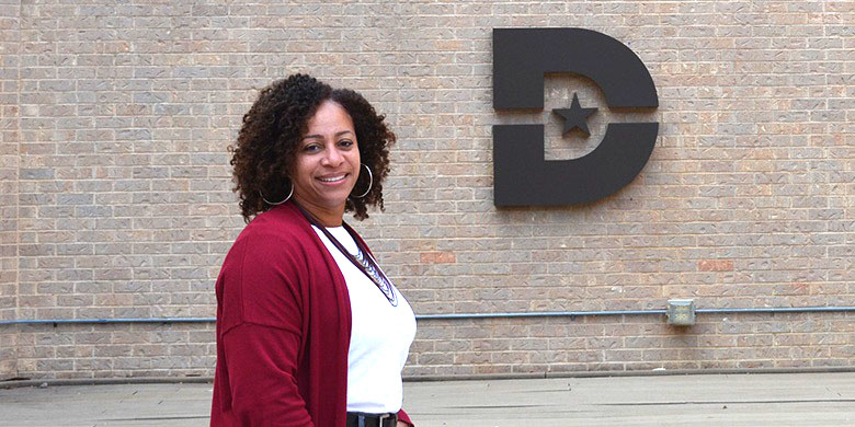 Danita Bradshaw-Ward in front of brick wall with a Dallas College 