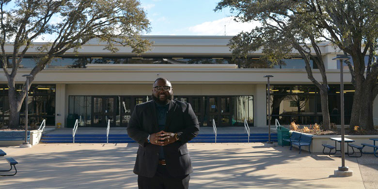Dr. Brandon Morgan standing in front of campus building.