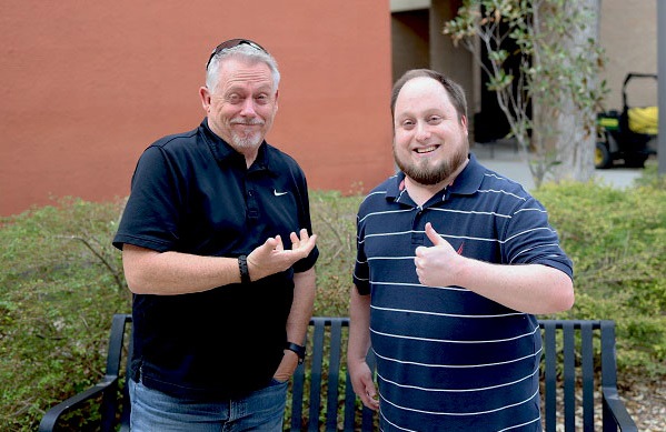 Ken and Joshua Kidd standing outside campus building.