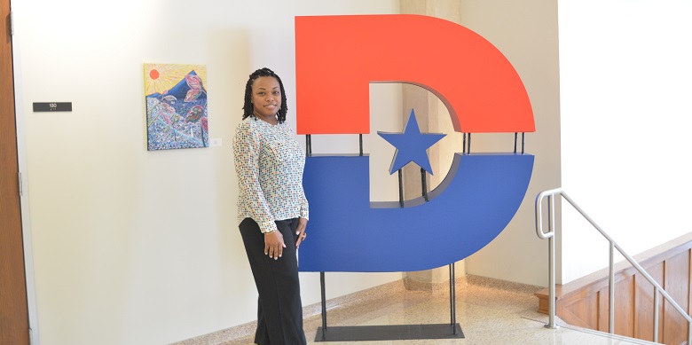 Nicosha Porter standing next to big D sculpture.