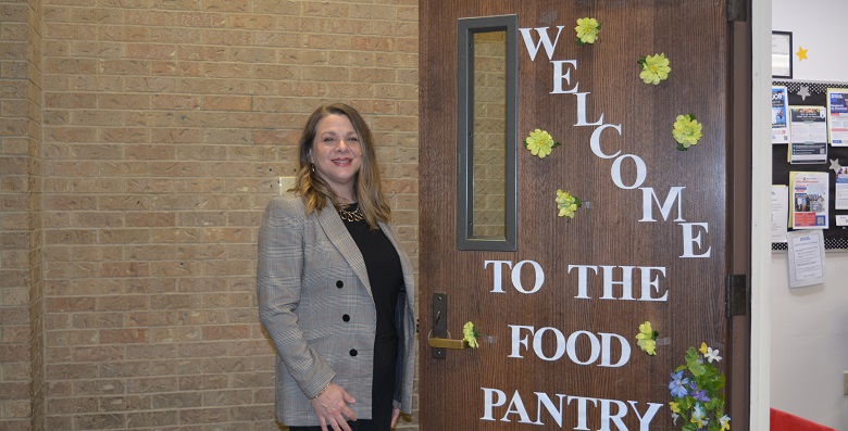 Wendy Gardner standing in front of food pantry door.