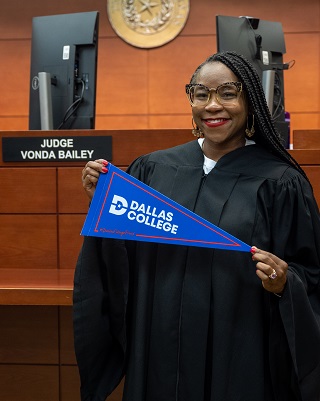 Judge Vonda Bailey holding Dallas College pennant