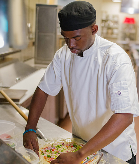 Tairan Lockett making a vegetable pizza.