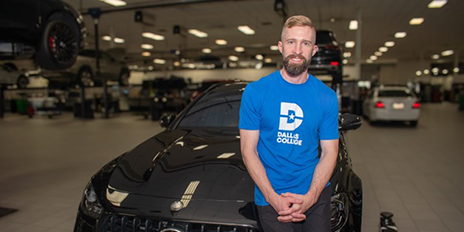 Chris Manning leaning against a car