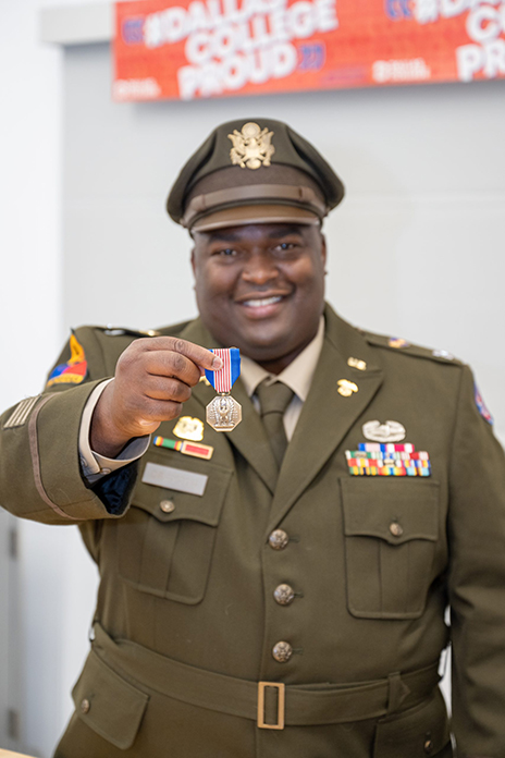 Army Captain Steven Drayton holding the Soldier's Medal.