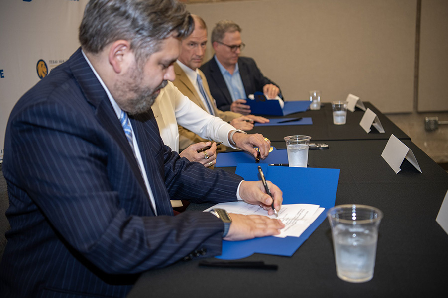 Chancellor Lonon signing a document.