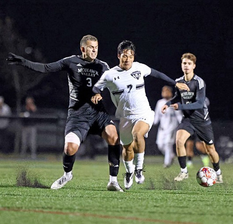 Richland Men's soccer player #7 fighting for possession of the ball with a Mohawk Valley defender.