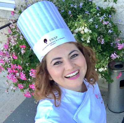 Sayada Rapalo taking a selfie in front of pink, white, blue, and purple flowers.