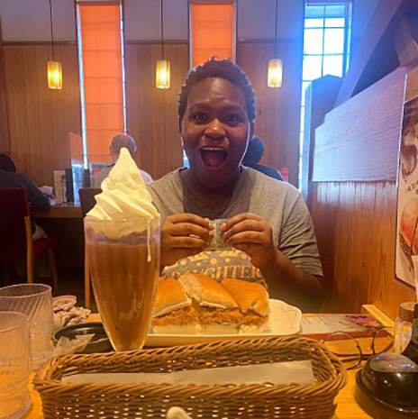 Zoe Phillips sitting at a table with food in front of her