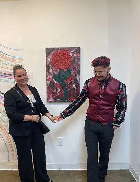 Osvaldo and his mom together with Osvaldo's art hung on the wall in the background.