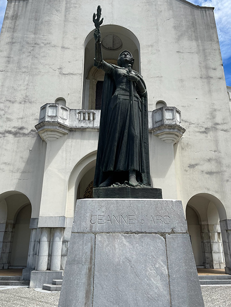 A statue holding a torch and sword.