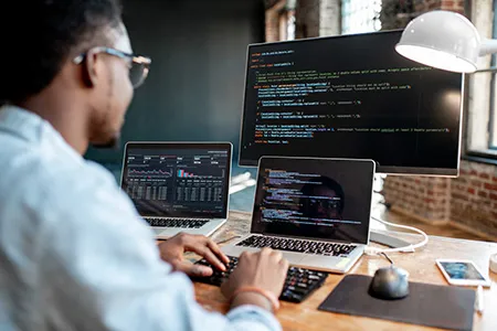 A person sits in front of a laptop computer