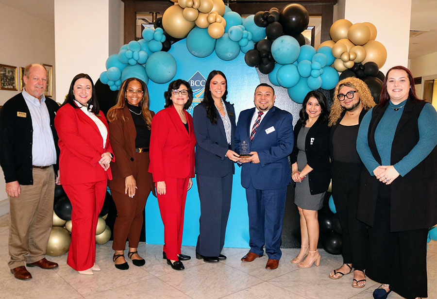 Nine members of Student Care Network pose with Bellwether Finalist Award