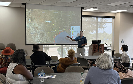 Presenter pointing at map on screen
