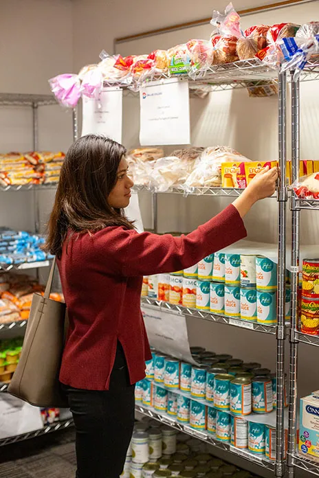 Shopper at food pantry looking at a package of pasta.