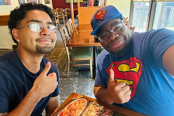 Alonso Jimenez and Timothy McDuffie take a selfie at a restaurant