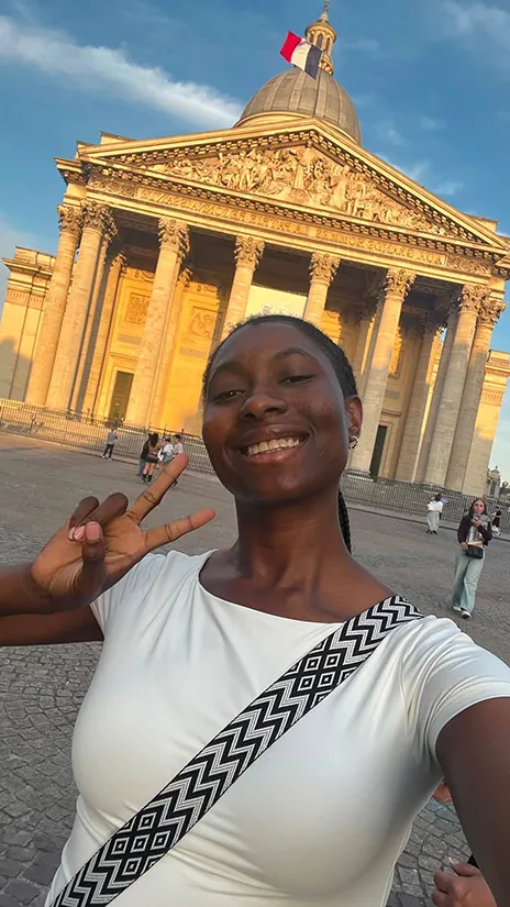 Emmanuella Iwuji posing in front of historic building in France.