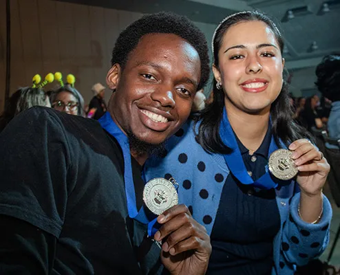 Joseph Assani and Fernanda Hernandez holding up their medals.