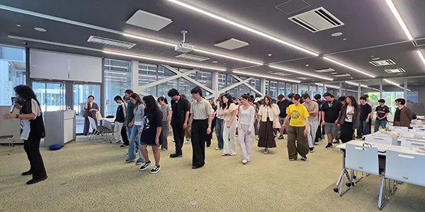 A group of Japanese students and Dallas College students participate in a line dance session.