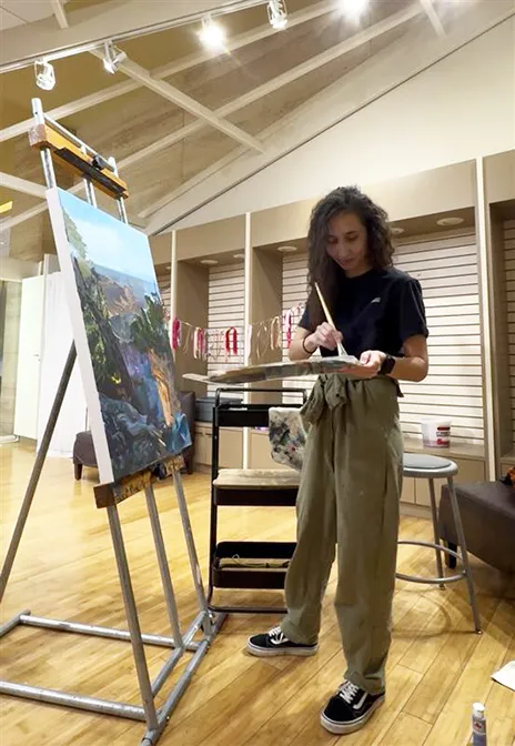 Lolita Khugayeva painting in the studio.