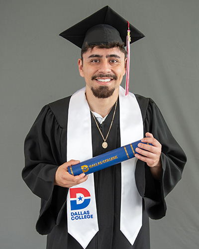 Leonardo Cortes is pictured wearing a cap and gown and holding a diploma