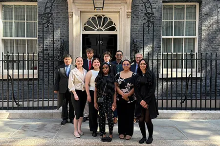 A group of Dallas College students stand outside 10 Downing Street in London.