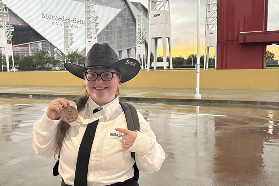 Rosemary Pate with cowboy hat holding SkillsUSA medal.