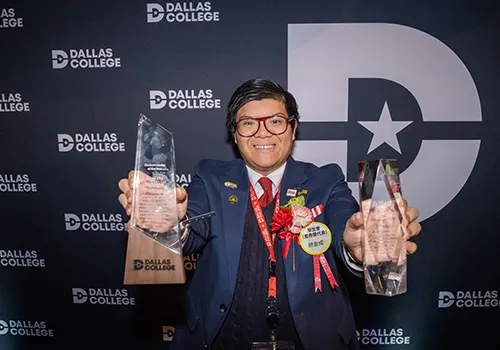 Kent Ho holds up two awards at the Student Leadership Awards and Sneaker Ball event.