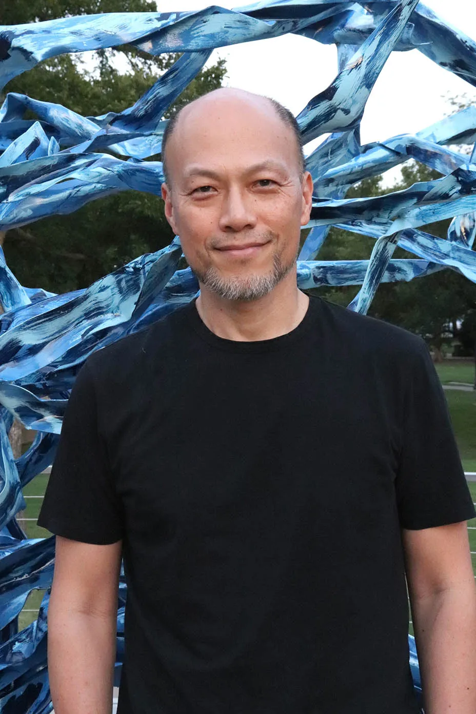 Stephen Lee standing in front of one of his sculptures.