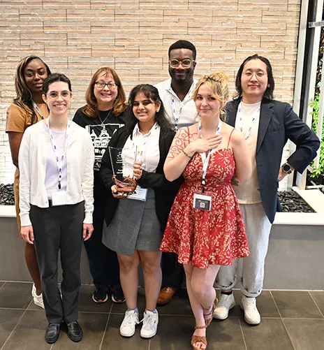 Seven students at TIPA posing with trophy.