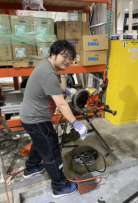 Xinglei Hu moving working on equipment at HVAC lab.