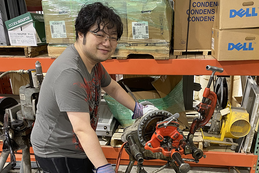 Xinglie Hu working on piece of equipment in HVAC lab.