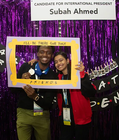 Two students pose in a frame.