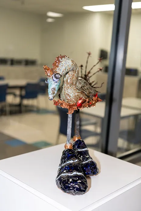 Sculpture of a creature wearing large shoes.