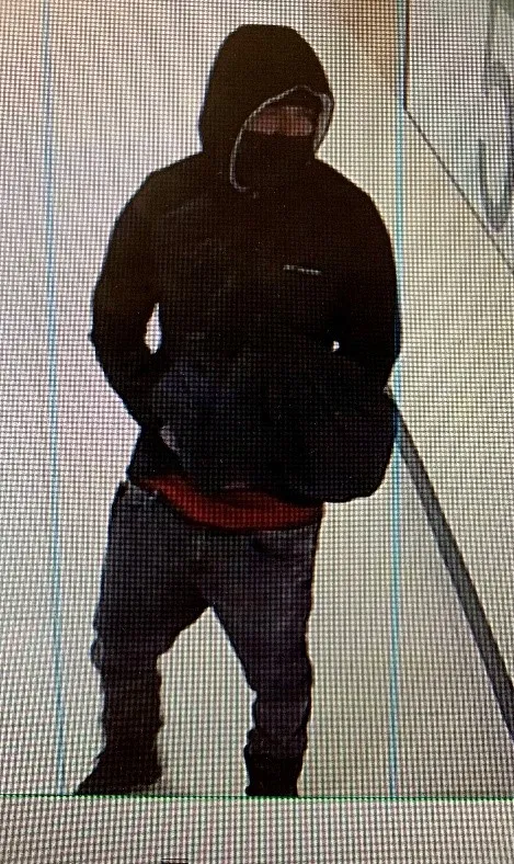 young hispanic man in black jacket with black mask.