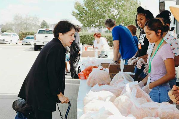 Food pantry volunteers bag groceries to prepare for guests