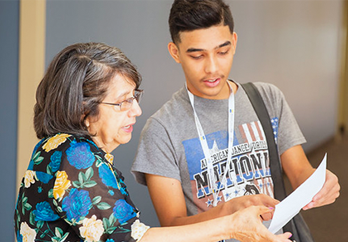 A student and an instructor review a piece of paper together