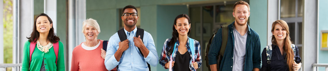multiple students standing in a line facing forward smiling