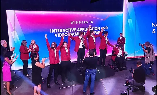 winners standing in a line holdings hands up