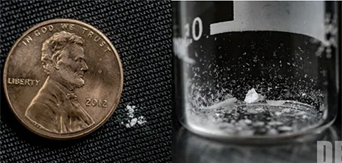 2 milligrams of fentanyl shown next to a penny for size comparison along with a test tube holding fentanyl