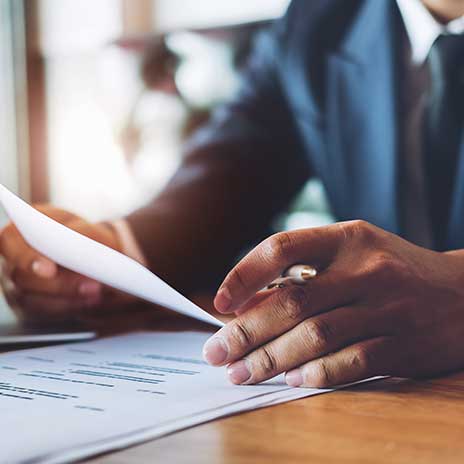 person sitting at desk holding a paper