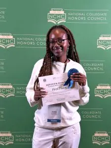 Student smiles for the camera with her certificate.
