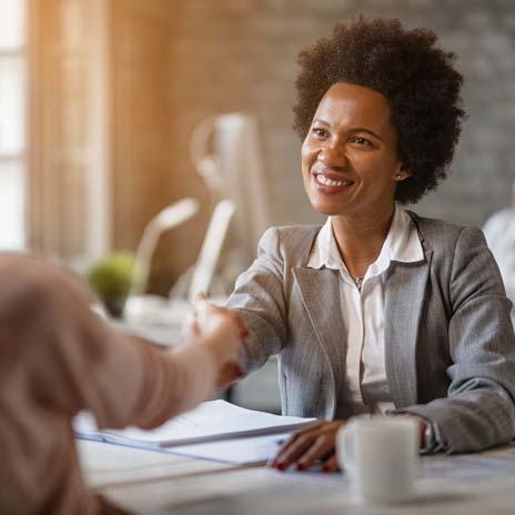 a woman shaking hands with another person talking to them