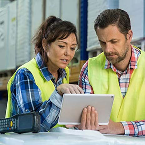 two logistics employees looking at a digital work device together