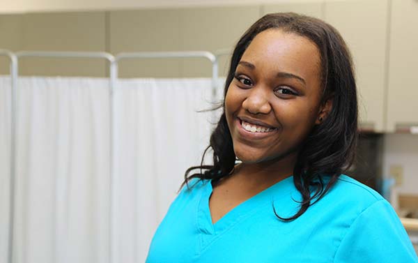 Student Nurse smiles while working in a lab